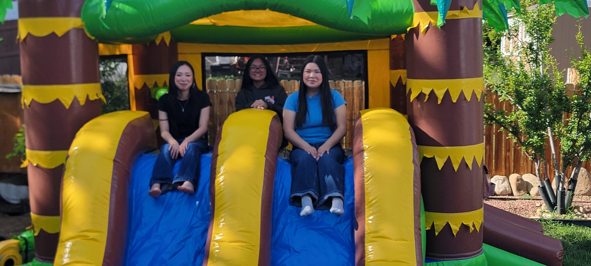 Happy customers enjoying Jamaican Peaks bouncy castle